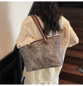 Vista posteriore di una grande borsa tote vintage grigia con sottili spalline marroni