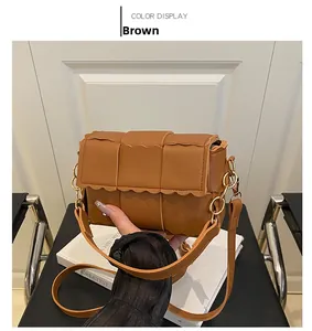 Détail du sac bandoulière tissé marron avec bordure festonnée et chaîne dorée
