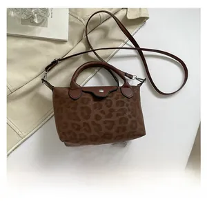 Bolso con estampado de leopardo marrón junto a un móvil para comparar el tamaño real