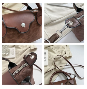 Detail of brown contrast handbag featuring silver metal buckle and premium stitching