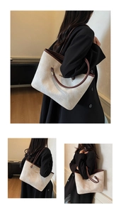 Dettaglio di borsa tote in tela con rifiniture in pelle marrone e logo dorato