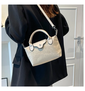 Close-up of cream handbag featuring silver metallic buckle and light leopard print detail
