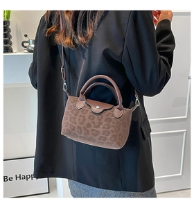 Detail of trendy brown leopard print handbag with leather top handles and suede texture