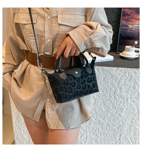 Detail view of mini black leopard print tote bag with round handles and metal clasp