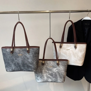 Three tote bags in grey and cream colors with textured finish and slim brown handles
