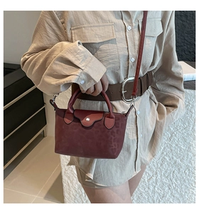 Detail of dark red leopard texture nylon tote bag with silver buckle and crossbody strap