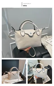 Detailed view of a white mini tote bag with black edge painting and adjustable strap