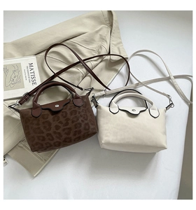 Detail of mini crossbody bags in leopard print and beige with adjustable shoulder straps