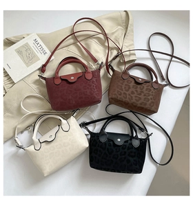Macro view of leopard print mini tote bags in wine, brown, cream, and black colors