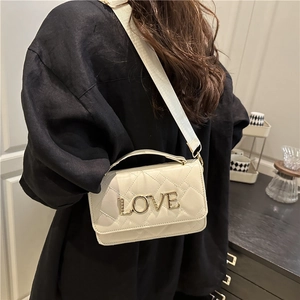 Sac cylindre matelassé beige avec lettres LOVE dorées et bandoulière réglable chic