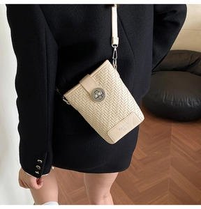 Detail of beige woven texture and metal buckle lock on a stylish women bucket bag