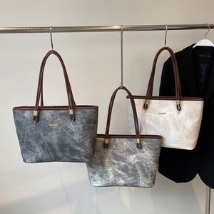 Tre eleganti borse tote con trama marmorizzata e logo dorato per il lavoro d'ufficio