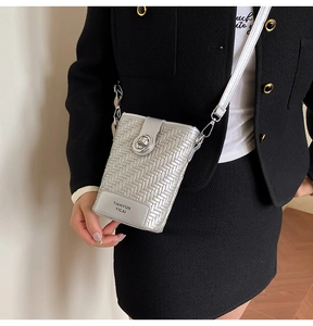 Detailed view of silver woven texture crossbody bag with elegant round metal swivel lock