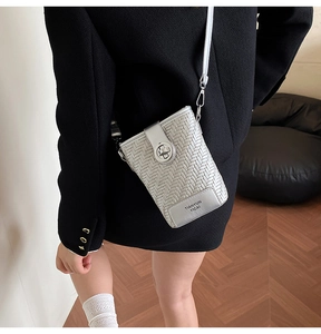 Detailed view of silver-grey woven texture bucket bag with metal twist lock and strap