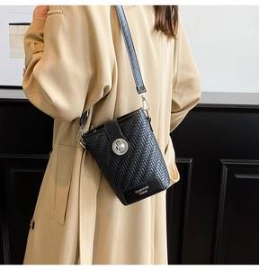 Macro detail of black woven texture and silver twist-lock on stylish bucket bag