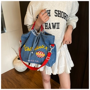 Detail of blue denim tote bag with red handles and yellow Chill Vibes embroidery art