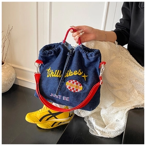 Detail of denim tote with Chill Vibes embroidery and red woven rope handles
