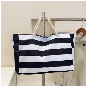 Detail van een grote gestreepte canvas shopper met stevige handvatten van wit henneptouw