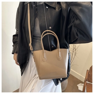 Detail der khakifarbenen Leder-Beuteltasche mit FASHION-Schriftzug und Schultergurt