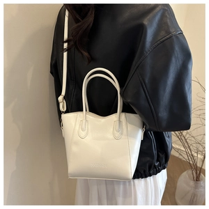 Detail der minimalistischen weißen Beuteltasche mit Doppelgriffen und modischer Prägung