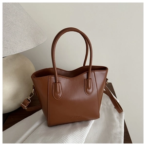 Detailansicht der braunen PU-Leder Beuteltasche mit Logo-Prägung und Metallbeschlägen