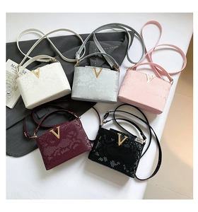 Detail showing high-capacity chic snakeskin pattern handbags with V-shaped metal hardware