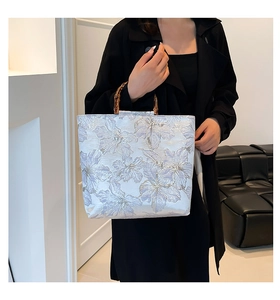 Detailed close-up of the elegant floral jacquard texture and natural bamboo handles