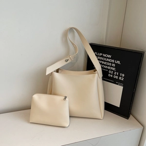 Detailed view of cream PU leather bucket bag with a matching small zipper pouch