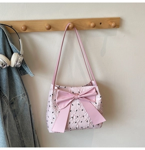 Détail du sac seau rose avec grand nœud et texture de tissu floral gaufré