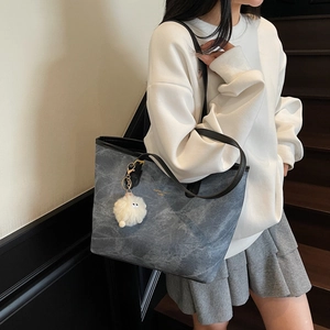 Grey marble texture tote bag with black handles and white fur pompom accessory