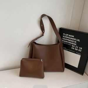 Detail of vintage brown bucket bag set with wide shoulder strap and matching pouch