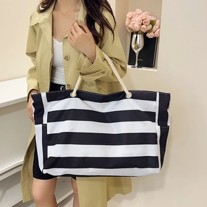 Grote gestreepte canvas tote bag met touwhandvatten getoond op een model