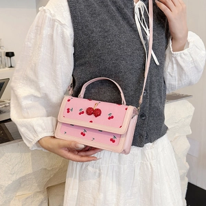 Borsa a tracolla rosa con stampa ciliegie e ciondolo 3D indossata da una modella