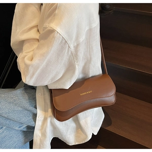 Détail d'un sac bandoulière marron en simili cuir avec lettrage doré FASHION & BAGS