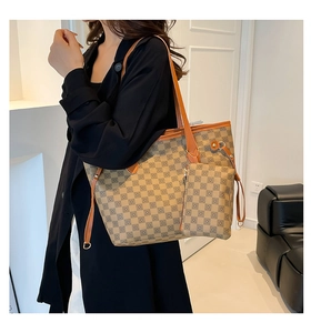 Side view of woman carrying a khaki vintage print tote bag with brown leather straps