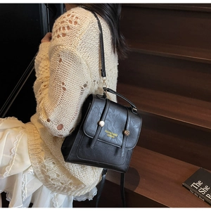 Détail d'un sac à dos en cuir grainé noir avec des accents métalliques dorés chic