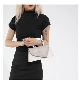 Détail du rabat en strass sur petit sac à main en cuir beige avec poignée métallique