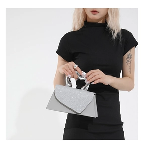 Détail du sac argenté pailleté avec poignée métallique torsadée porté par un modèle