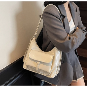 Side view of cream oil-leather tote bag with flap buckle detail shown on a model