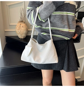 Close-up of white woven textured bucket bag with a matching mini coin purse attachment