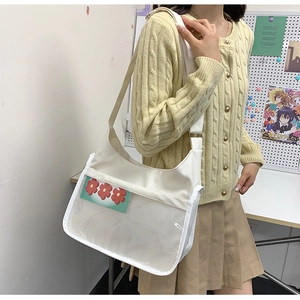 Detail view of white nylon shoulder bag with transparent PVC pocket and floral card