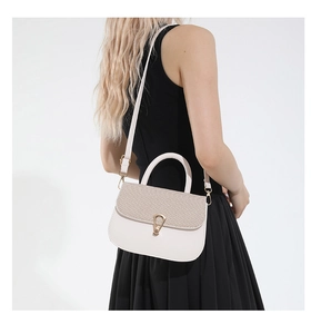 Detail view of cream white saddle bag showing woven texture flap and golden metal buckle