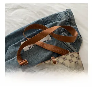 Detail of vintage bucket bag featuring anagram pattern and branded canvas shoulder strap