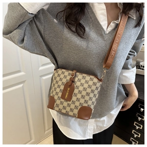 Detail of vintage bucket bag with beige canvas, geometric patterns and leather trim