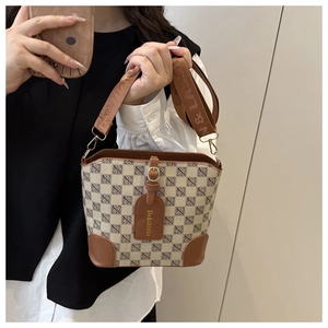 Detail of retro plaid bucket bag featuring jacquard fabric and brown leather trim