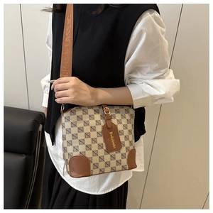 Detail of retro plaid bucket bag with brown leather tag and branded woven strap
