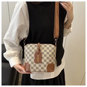 On-body view of a vintage plaid bucket bag with brown leather accents and wide strap
