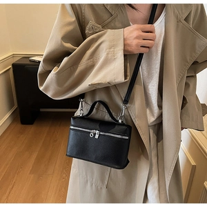 Detailed view of a black lychee texture mini leather crossbody bag worn by a model
