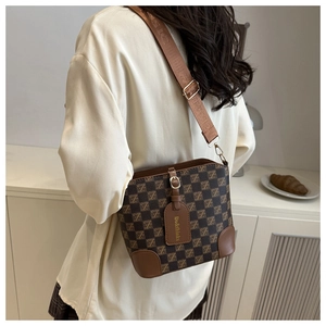 Close-up of retro checkered bucket bag with wide jacquard strap and brand logo detail