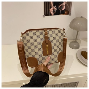 Close-up of retro bucket bag with geometric jacquard canvas and brown leather details